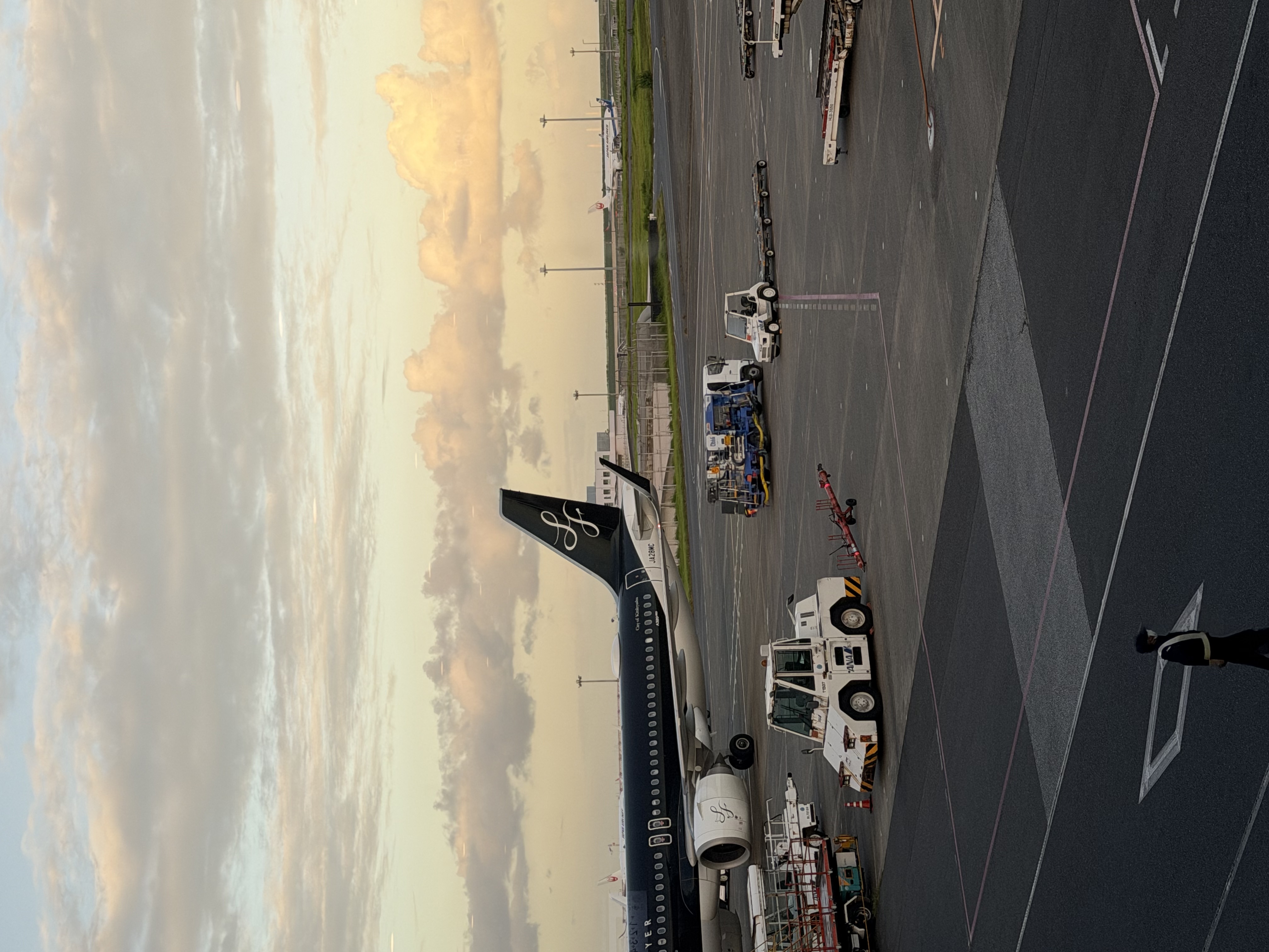 An airplane on the runway beneath a warm evening sky before the trip from Tokyo to Fukuoka